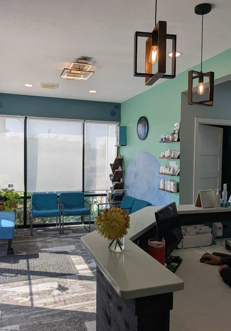 Bright and welcoming chiropractic office interior with patient reception desk and seating area.